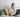 Woman on couch with laptop and headphones taking notes