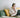 Woman on couch with laptop and headphones taking notes